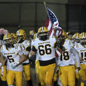 Montour’s Santino Coradi leads the Spartans onto the field before their game against West Allegheny on Friday, Oct. 24, 2025, in North Fayette.