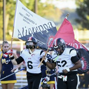 Aliquippa’s Joseph Work (6) and Justus Starks lead the Quips onto the field before their game against Mars on Sept. 12.
