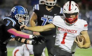 Leechburg's Tristan Zalenski (left) attempts to grab ahold of Neshannock quarterback Jino Mozzocio during the first half of a WPIAL Class A playoff game Friday at Veterans Memorial Field.