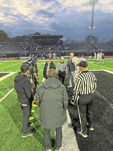 Captains from Upper St. Clair and Plum meet for the coin toss before their WPIAL Class 5A playoff game Friday.