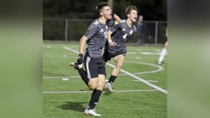Patrick Connors (12) runs to the sidelines and asks for noise from the Quaker Valley student section during a WPIAL Class 2A semifinal against Deer Lakes.