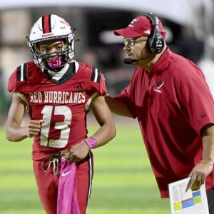 New Castle quarterback Marino Graham listens to coach Fred Mozzocio’s play call during the fourth quarter Oct. 3 at Taggart Stadium.