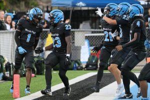 Woodland Hills’ Scoop Smith (1) celebrates with Taylor Reid (23) and his teammates after scoring a first-quarter touchdown against Penn-Trafford on Sept. 12.