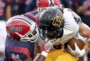McKeesport’s Avont Hudson grabs the facemask of Thomas Jefferson’s Tyler Eber during their Sept. 5 game at McKeesport.