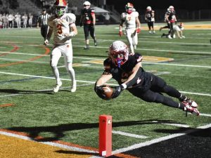Avonworth’s Dimitri Velisaris dives for the end zone past North Catholic defenders during the WPIAL Class 3A semifinals Friday, Nov. 14, 2025 at North Allegheny’s Newman Stadium.
