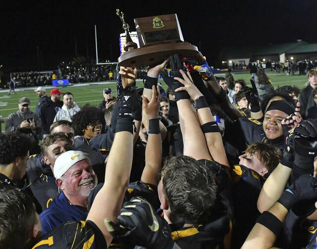 The Central Catholic football team celebrates with the WPIAL Class 6A trophy after defeating North Allegheny, 42-7, on Saturday at Pine-Richland