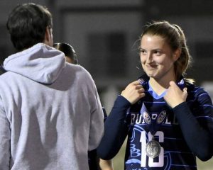Burrell’s Katie Kohler gets her silver medal from coach Frank Nesko after the PIAA Class 2A championship game against Archbishop Wood on Friday at Northeastern York High School.