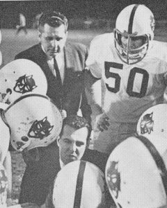 Leechburg coach Frank Cignetti Sr. (kneeling) goes over strategy with the Blue Devils on Nov. 19, 1965 in the WPIAL title game at Graham Field in Wilkinsburg. Looking on are assistant coach Bob Costello and Joe Romanowski (50) as Leechburg rolled to a 37-7 rout over California.