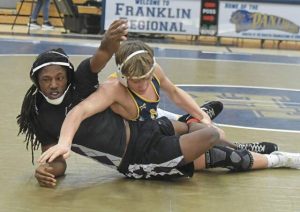 Obama Academy’s Charles Bottoms works to escape from Norwin’s Dom Butera (right) during a 133-pound match Feb. 4.