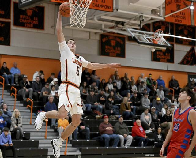 Latrobe’s Ian DeCerb elevates to dunk against Richland’s Alex Bond on Friday.