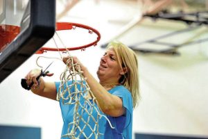 Brentwood coach Rachel Thomas cuts down the net after the Spartans won the 2019 section title.
