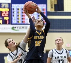 Mars’ Mya Moore scores past Franklin Regional’s Madelyn Catello and KC Yaniga during their game on Monday, Dec. 1, 2025, in Murrysville.
