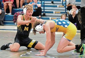 Norwin’s Nathan Klingensmith pushes Canon-McMillan’s Aiden Finnigan away during their 138-pound match Dec. 4, 2024. (Paul Schofield | TribLive)