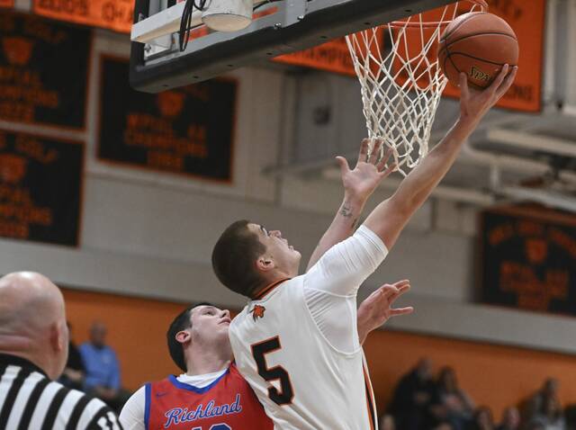 Latrobe’s Ian DeCerb scores past Richland’s Glaiden Hale on Friday. (Chaz Palla | TribLive)
