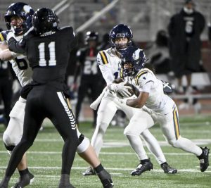 Central Catholic’s Chrys Black takes a hand-off from Owen Herrick during their PIAA Class 6A semifinal against Harrisburg on Saturday, Nov. 29, 2025, at Mansion Park in Altoona. (Christopher Horner | TribLive)