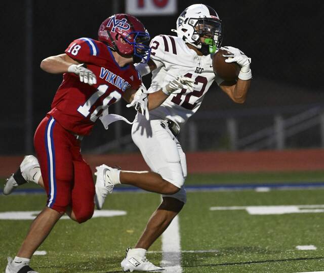 Greensburg Central Catholic’s Samir Crosby pulls in a touchdown pass past Mt. Pleasant’s Robert Hixson during a game in August. (Chaz Palla | TribLive)
