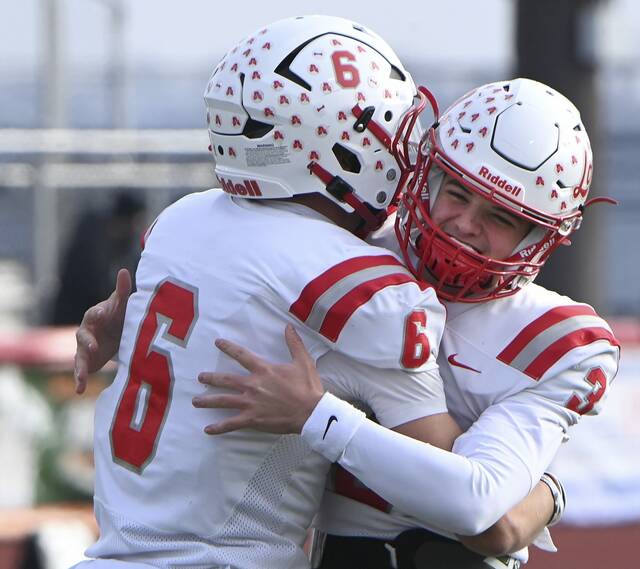 Avonworth quarterback Carson Bellinger hugs Jaden Jones after they connected for a touchdown during the PIAA Class 3A state championship game against Northwestern Lehigh on Saturday, Dec. 6, 2025, at Cumberland Valley. (Christopher Horner | TribLive)