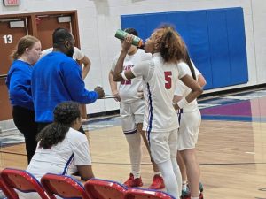 Jeannette girls basketball coaches Jenna Lusby (left) and Arnold Lusby draw up a play in a huddle Monday night against visiting Clairton. (Bill Beckner Jr. | TribLive)