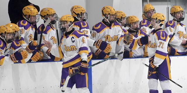 Plums Max Keller (left) and William Amen celebrate with the bench after setting up Tyler Bartos goal against Greensburg Salem on Monday, Nov. 24, 2025, at Pittsburgh Ice Arena. (Christopher Horner | TribLive)