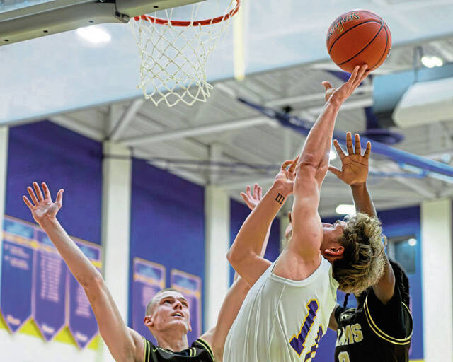 Plums Owen Proskin (10) attempts a shot over Highlands Troy Bielak (4) and Marquis Johnson (right) on Friday at Plum high School. (Andrew Palla | For TribLive)