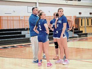 Hempfield coach Bob Madison (left) and his players look on during player introductions Saturday night at the Latrobe Wildcat Christmas Tournament. (Bill Beckner Jr. | TribLive)