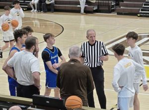 Hempfield (left) and Greensburg Salem players and coaches gather for a pregame huddle Tuesday night. (Bill Beckner Jr. | TribLive)
