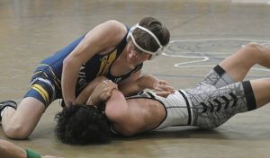 Norwins Nathan Klingensmith picks up back points against Penn-Traffords Evan Awai during the 145-pound match Wednesday. (Paul Schofield | TribLive)