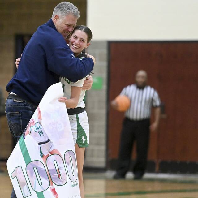 South Fayettes Juliette Leroux hugs her dad, former Penguin Francois Leroux, after scoring her 1,000th career point during the Lions game against Norwin on Saturday at South Fayette. (Christopher Horner | TribLive)