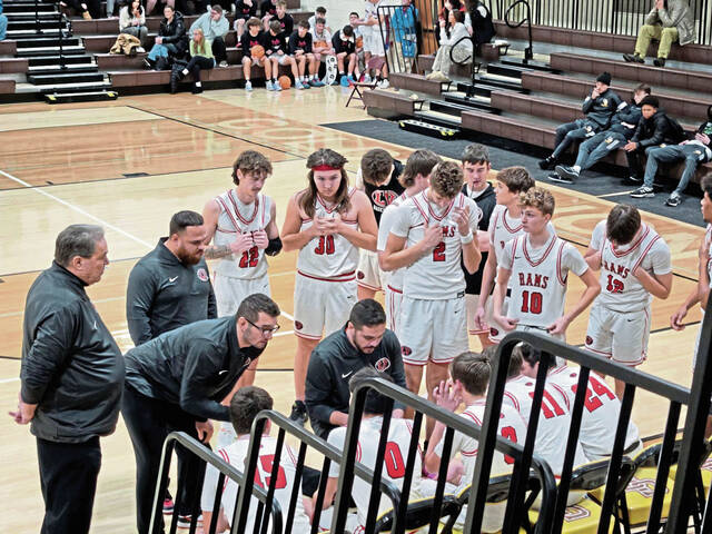 Ligonier Valley coach Dante Porter (kneeling) leads a huddle with his players during the Greensburg Salem Holiday Classic. (Bill Beckner Jr. | TribLive)