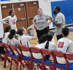 Jeannette coaches Jenna Lusby (center) and Arnold Lusby (right) talk to their Jeannette girls basketball team on Thursday night. (Bill Beckner Jr. | TribLive)
