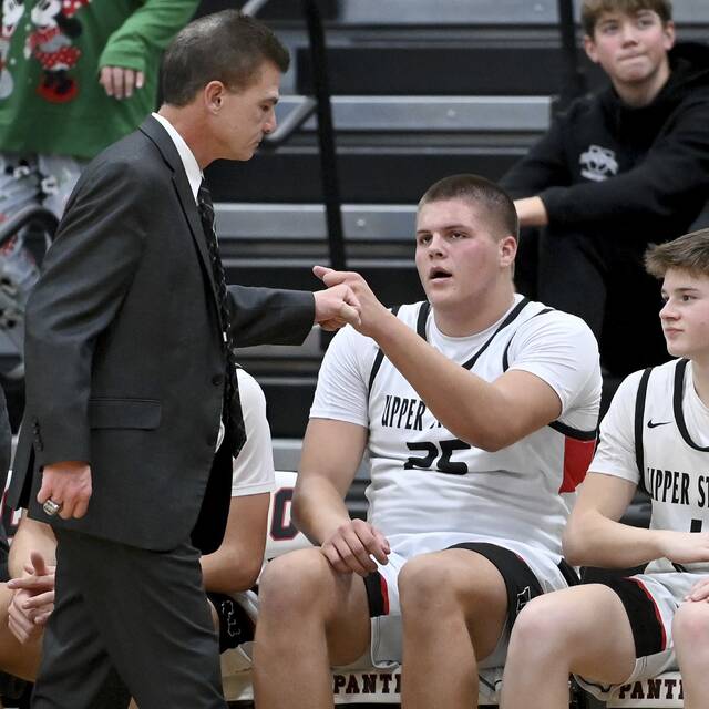 Upper St. Clair’s Ryan Robbins fist bumps head coach Danny Holzer during the fourth quarter against Norwin on Tuesday, Dec. 9, 2025, at USC. (Christopher Horner | TribLive)