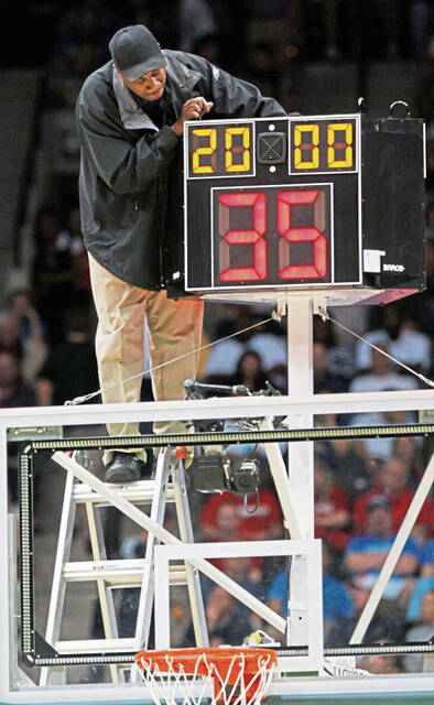 A worker fixes a shot clock during a 2010 NCAA Tournament game in Jacksonville, Fla. (AP)