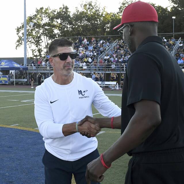 Mars coach Eric Kasperowicz shakes hands with Aliquippa coach Mike Warfield before their game Sept. 12, 2025. (Christopher Horenr | TribLive)