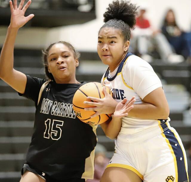 Shady Side Academys Leah Buford heads toward the basket to attempt to get off a shot Nov. 30, 2025, at the Play 4 Mae Showcase at Woodland Hills High School while being guarded by John Carrolls Camryn Almond. (Josh Rizzo | For TribLive)