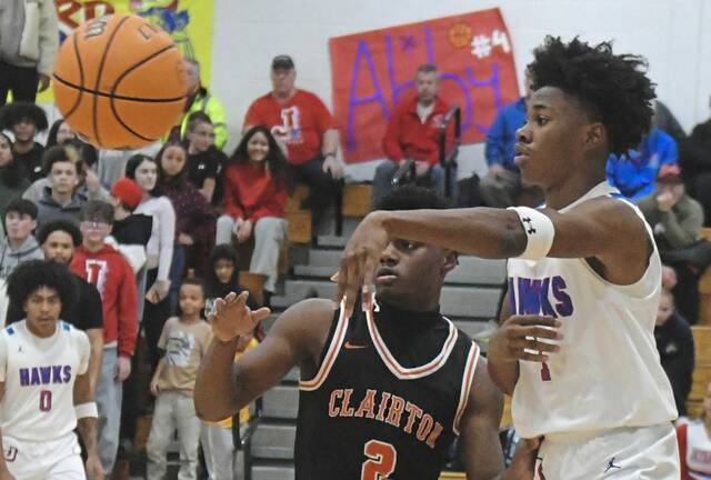 Jeannettes Kymone Brown passes the ball while defended by Clairtons Mike Ruffin on Jan. 13. (Paul Schofield | TribLive)