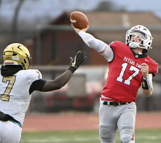 Peters Township quarterback Nolan DiLucia throws a pass under pressure from Bishop McDevitts Maurice Barnes Jr. during their PIAA Class 5A semifinal on Saturday, Nov. 29, 2025, at Mansion Park in Altoona. (Christopher Horner | TribLive)