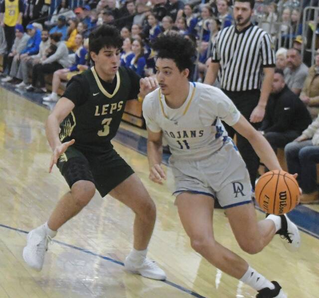 Derry junior Stanley Rajkovich (11) drives past Belle Vernons Vincenzo Francia on Friday. (Paul Schofield | TribLive)