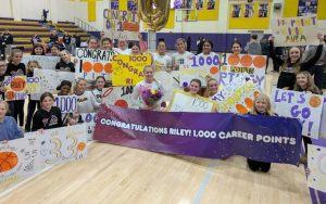Plum players and fans celebrate Riley Stephans reaching 1,000 points after a home win over Penn-Trafford on Wednesday. (Mike Love | TribLive)