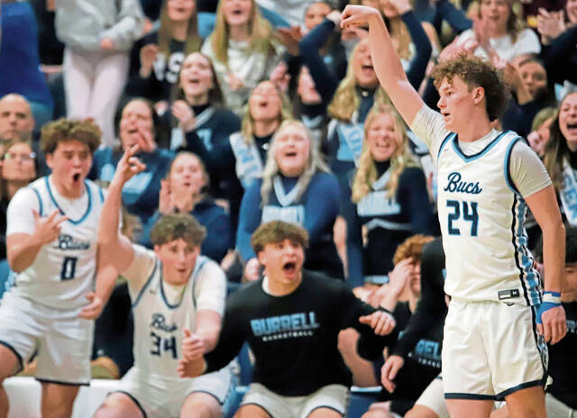 Burrell senior guard Ryan Wass follows through after making a 3-pointer while the bench celebrates Tuesday night at Burrell. Wass made 9 3-pointers and finished with 27 points. (Josh Rizzo | For TribLive)