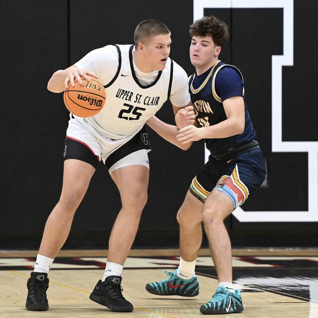 Upper St. Clairs Ryan Robbins works against Norwins Josh Lenart on Dec. 9, 2025. (Christopher Horner | TribLive)