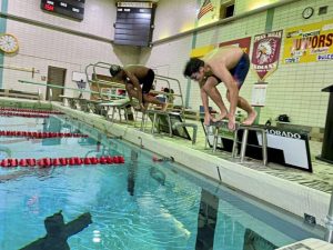 Penn Hills swimmers Kingsley Nwachukwu (left) and Anthony Sipple dive into the Linton Middle School pool in 2024. (Haley Daugherty | TribLive)