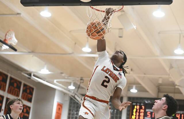 Latrobes Rob Young dunks over Franklin Regionals Oliver Leven and Anthony Mitchell on Jan. 30. (Chaz Palla | TribLive)
