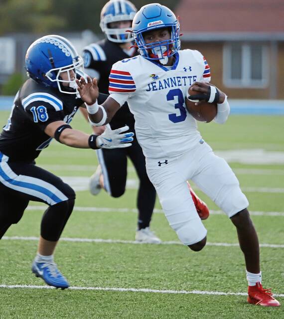 Jeannette quarterback Kymone Brown looks to evade Leechburg senior Matthew Scitticat on a 11-yard run in the first quarterback Sept. 19, 2025, at Veterans Memorial Field. (Josh Rizzo | For TribLive)
