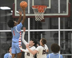 Jeannettes Kymone Brown scores over Greensburg Central Catholics JT Stawovy and Tommy Dlugos on Jan. 9. (Chaz Palla | TribLive)