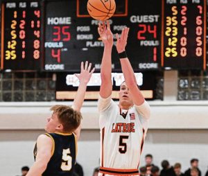 Latrobes Ian DeCerb hits a 3-pointer over Mars Austen Wroblewski during a WPIAL Class 5A playoff game Thursday at Greater Latrobe High School. (Chaz Palla | TribLive)