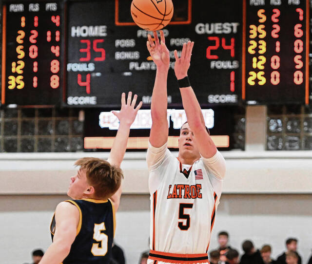 Latrobes Ian DeCerb hits a 3-pointer over Mars Austen Wroblewski during a WPIAL Class 5A playoff game Thursday at Greater Latrobe High School (Chaz Palla | TribLive)