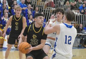 Deer Lakes Dylan Ferraro (25) drives into Derrys Izak Lenhart in a WPIAL Class 4A playoff game Friday. (Paul Schofield | TribLive)