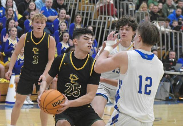 Deer Lakes Dylan Ferraro (25) drives into Derrys Izak Lenhart in a WPIAL Class 4A playoff game Friday. (Paul Schofield | TribLive)