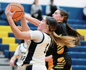 Freeports Keiley Reiser drives on Deer Lakes Molly Facster on Feb. 9 at Freeport Area Middle School. (Chaz Palla | TribLive)