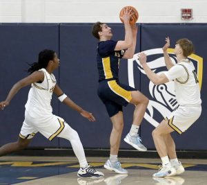 Mt. Lebanon’s Liam Sheely scores between Norwin’s Chris McKnight and Potter Brozeski during their game on Tuesday, Jan. 27, 2026, at Norwin. (Christopher Horner | TribLive)